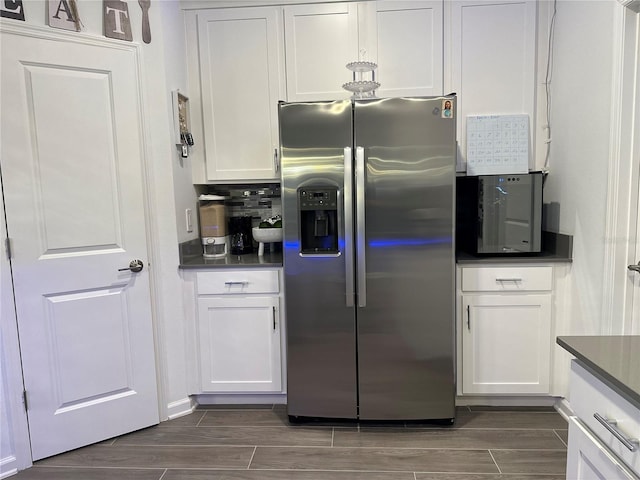 kitchen featuring white cabinetry and stainless steel refrigerator with ice dispenser