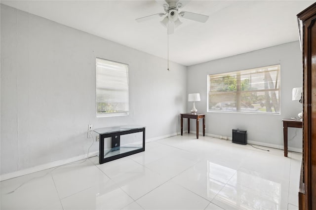 tiled spare room with ceiling fan