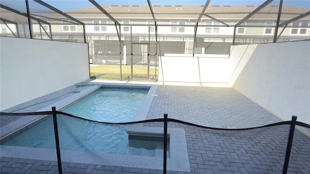 view of swimming pool featuring glass enclosure and a patio area