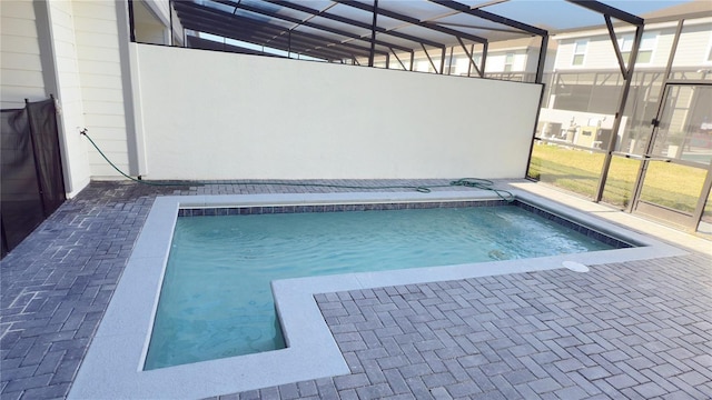 view of swimming pool featuring a lanai