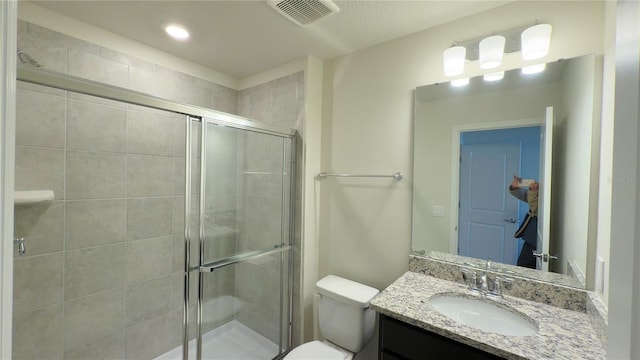 bathroom featuring vanity, an enclosed shower, and toilet