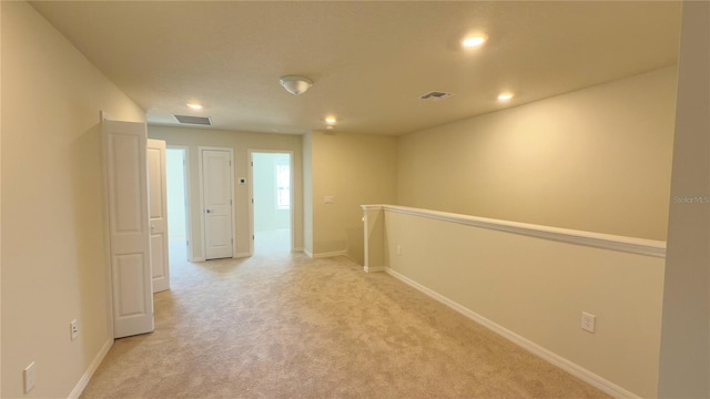 hallway featuring light colored carpet