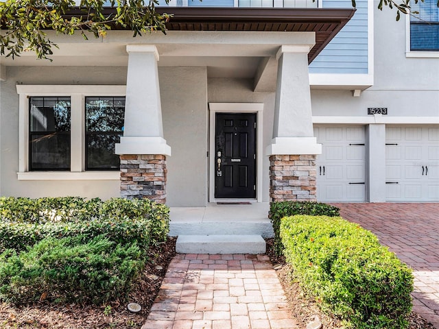 doorway to property with a garage and covered porch