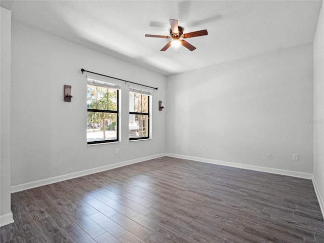 empty room with dark hardwood / wood-style flooring and ceiling fan