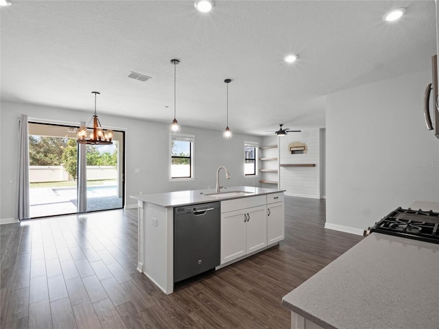 kitchen with decorative light fixtures, white cabinetry, sink, stainless steel appliances, and a center island with sink