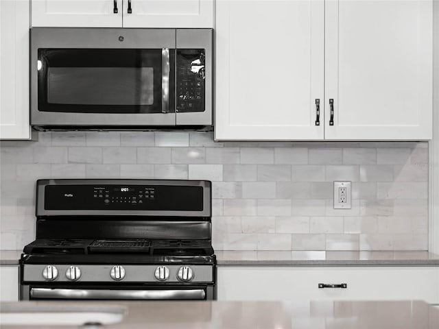 kitchen with backsplash, appliances with stainless steel finishes, and white cabinets