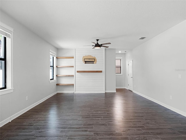 unfurnished living room featuring dark hardwood / wood-style floors and ceiling fan