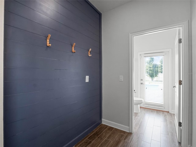 doorway featuring wooden walls and dark hardwood / wood-style floors