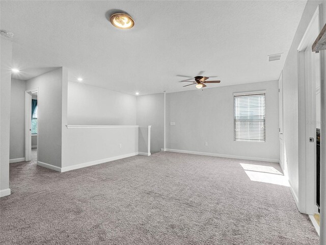 empty room featuring ceiling fan, carpet floors, and a textured ceiling