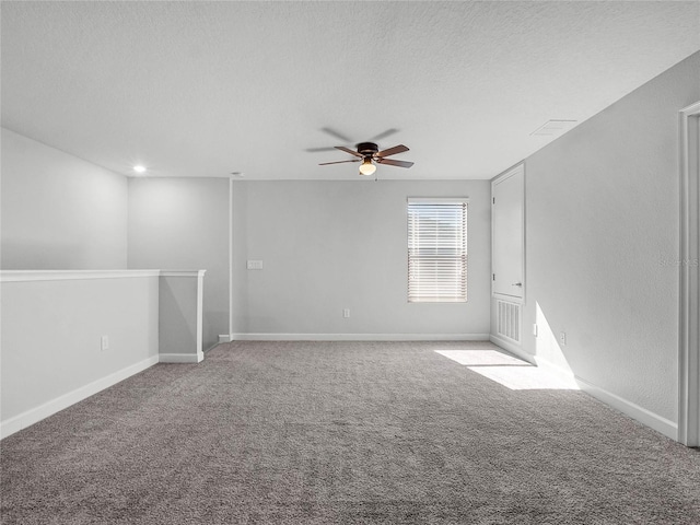 spare room featuring ceiling fan, a textured ceiling, and carpet flooring