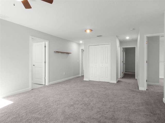 unfurnished bedroom with light colored carpet, ceiling fan, and a closet