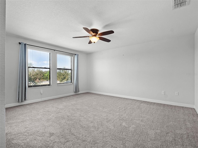 carpeted empty room featuring ceiling fan and a textured ceiling