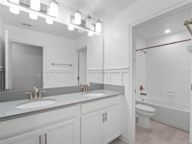 full bathroom featuring vanity, tiled shower / bath combo, tile patterned floors, and toilet