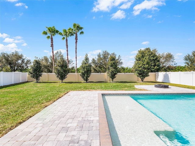 view of swimming pool with a lawn, a patio, and an outdoor fire pit