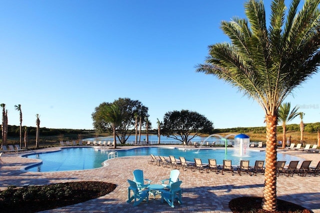 view of pool with pool water feature and a water view