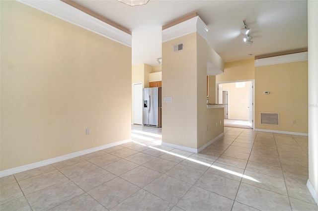 spare room with ornamental molding, light tile patterned floors, and track lighting