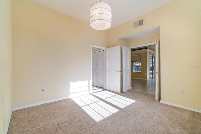 unfurnished bedroom with light carpet and a closet