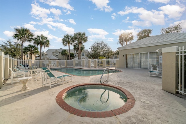 view of swimming pool featuring a hot tub and a patio