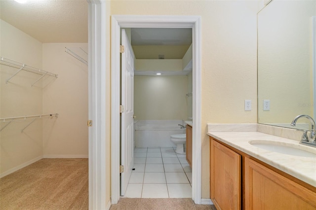 full bath with a washtub, a spacious closet, toilet, vanity, and tile patterned floors