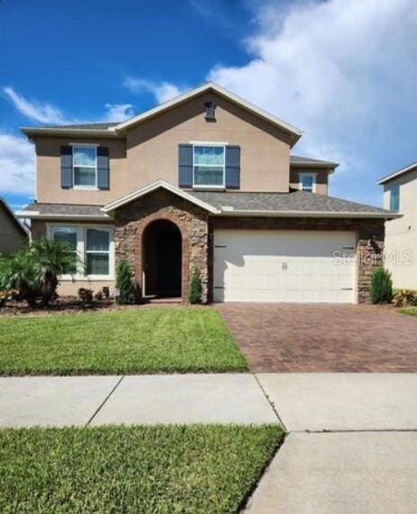 view of front of property featuring a garage and a front lawn