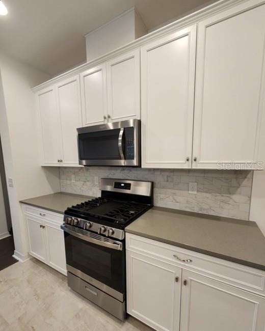 kitchen featuring tasteful backsplash, stainless steel appliances, and white cabinets