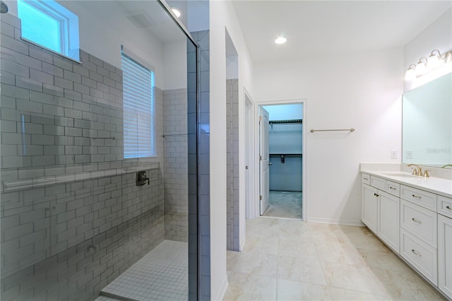 bathroom with a walk in closet, recessed lighting, vanity, a walk in shower, and baseboards