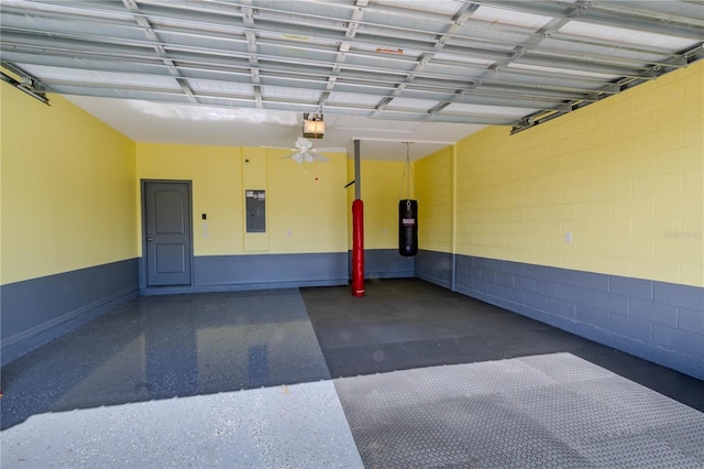 garage with concrete block wall, electric panel, and a garage door opener