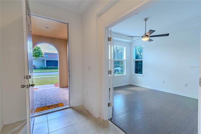 entrance foyer featuring light tile patterned floors, a ceiling fan, and baseboards