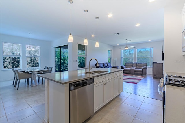 kitchen featuring a center island with sink, open floor plan, stainless steel appliances, white cabinetry, and a sink