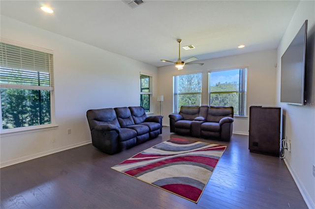 living area with hardwood / wood-style floors, a ceiling fan, visible vents, and baseboards