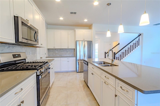 kitchen with visible vents, decorative backsplash, stainless steel appliances, white cabinetry, and a sink