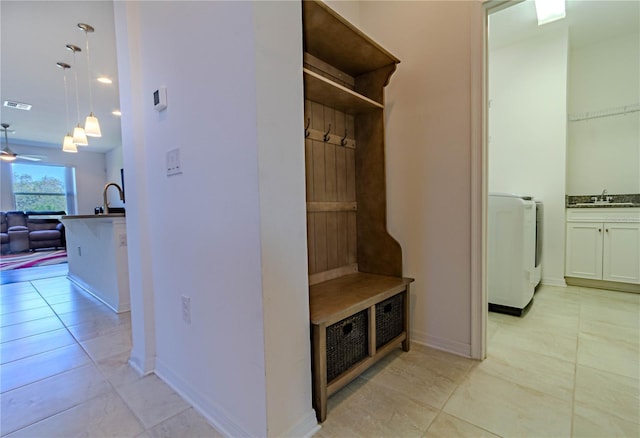 mudroom featuring washer / clothes dryer, visible vents, a sink, and light tile patterned flooring