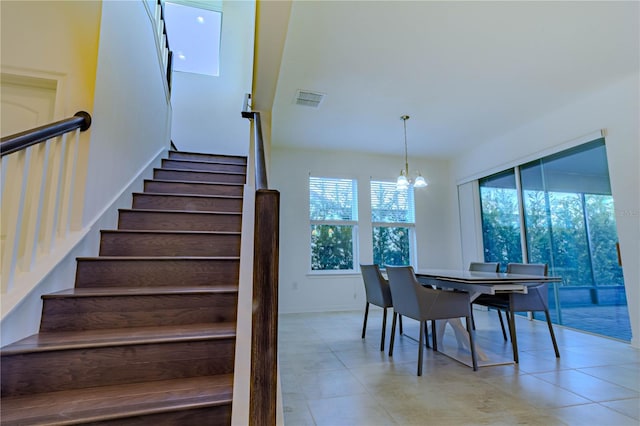 dining space with baseboards, stairs, visible vents, and a notable chandelier