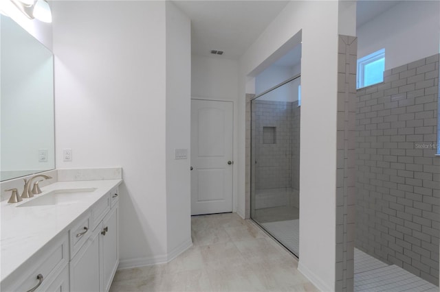 full bathroom featuring a stall shower, baseboards, visible vents, and vanity