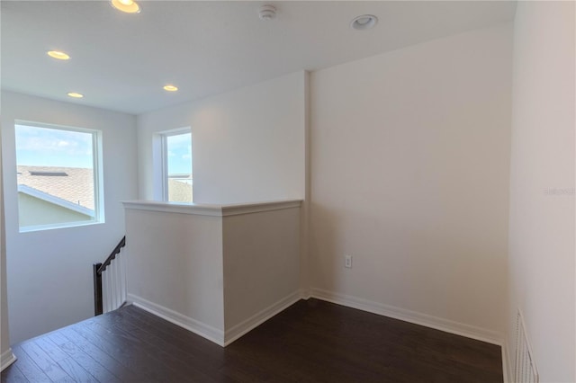 unfurnished room with dark wood-style flooring, recessed lighting, radiator, visible vents, and baseboards