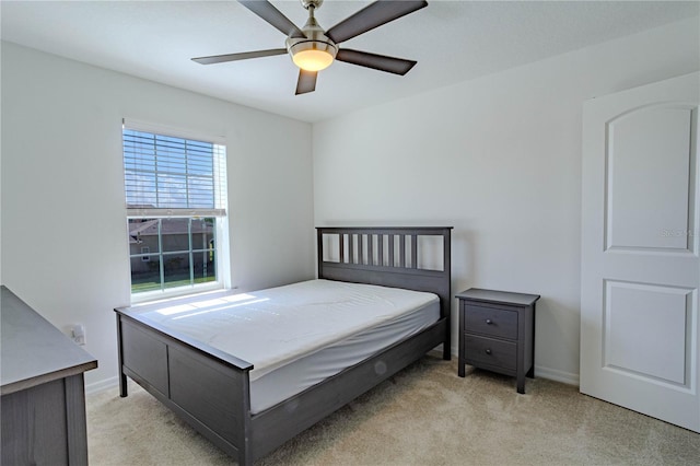 bedroom featuring light carpet, ceiling fan, and baseboards