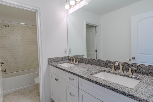 full bath featuring a sink, shower / bathing tub combination, toilet, and double vanity