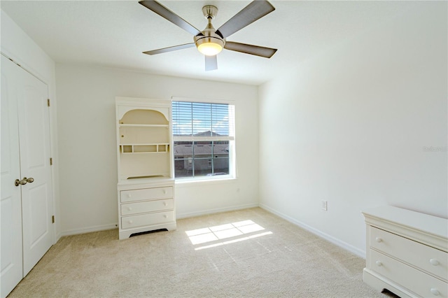 unfurnished bedroom with carpet, a ceiling fan, and baseboards