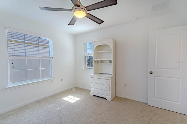 unfurnished bedroom with light carpet, ceiling fan, visible vents, and baseboards