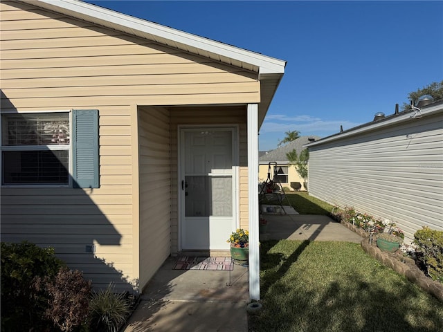 doorway to property with a lawn