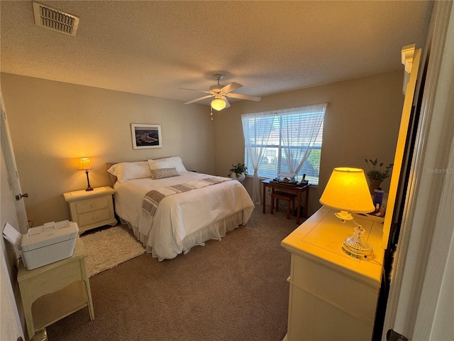 carpeted bedroom featuring ceiling fan and a textured ceiling