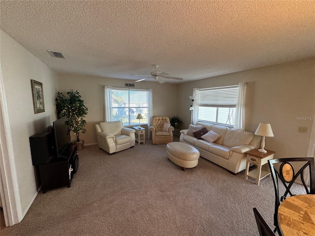 carpeted living room featuring ceiling fan, a healthy amount of sunlight, and a textured ceiling