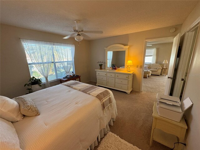 482 Hildalgo Dr, The Villages, FL 32159 - bedroom featuring light carpet, a textured ceiling, and a ceiling fan