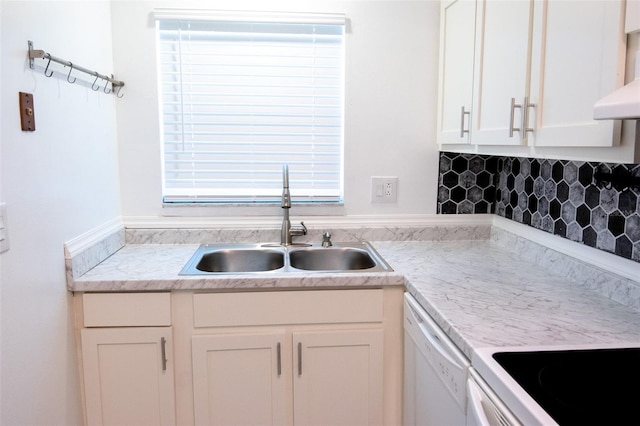 kitchen featuring white dishwasher, sink, tasteful backsplash, and white cabinets