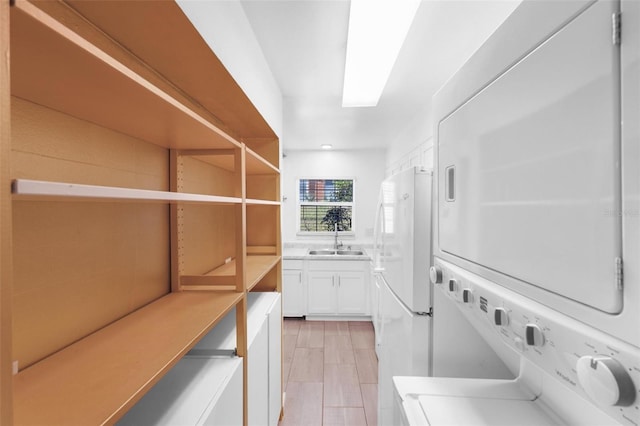 laundry room with stacked washer and dryer and sink