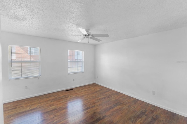 spare room with dark wood-type flooring, ceiling fan, and a textured ceiling