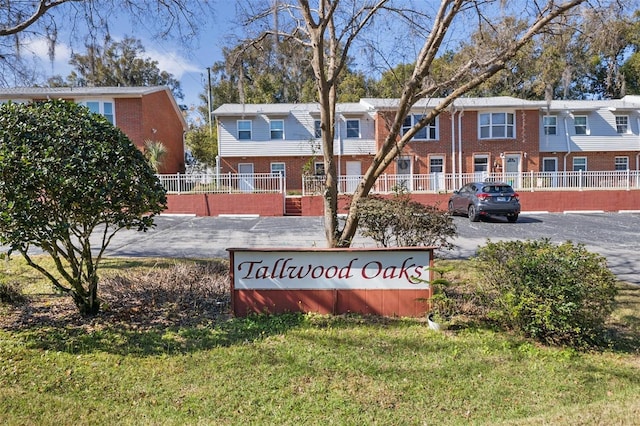 community / neighborhood sign featuring a lawn