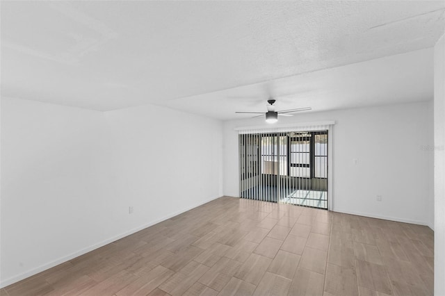 empty room with ceiling fan and light hardwood / wood-style flooring