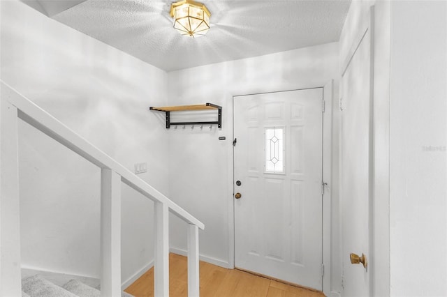 entryway featuring light hardwood / wood-style floors and a textured ceiling