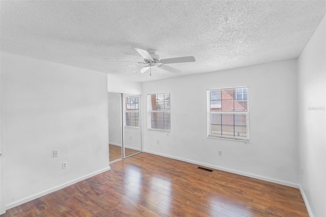 empty room with hardwood / wood-style floors, a textured ceiling, and ceiling fan